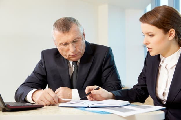 Homem e mulher em escritório analisando tradução jurídica.