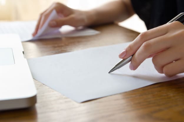 Tradução juramentada Mulher fazendo correção de tradução juramentada em documentos.