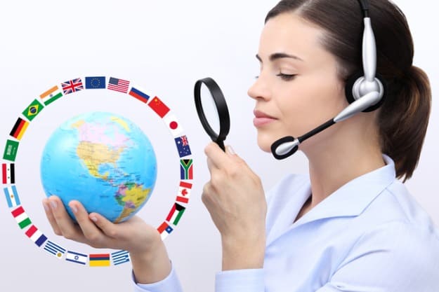 Tradução juramentada Profissional em tradução juramentada olhando globo terrestre e sua variação de idiomas com lupa.