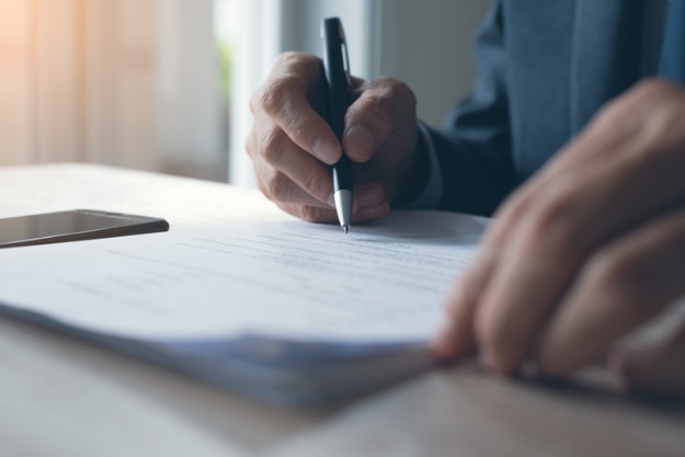 homem assinando tradução juramentada com reconhecimento de firma