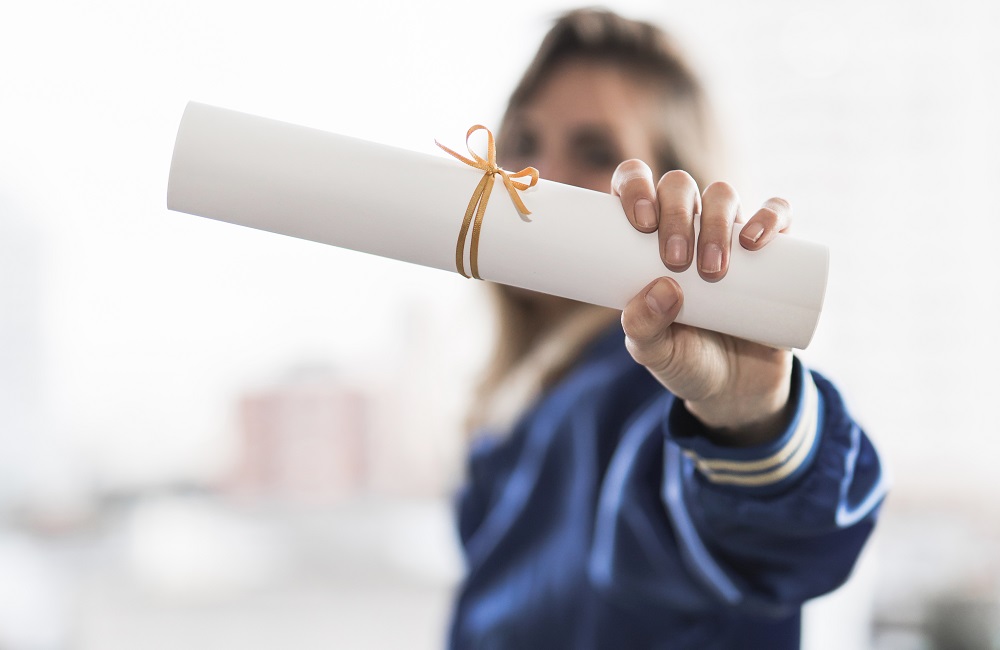 pessoa segurando um diploma após ter passado por tradução juramentada do português para o francês